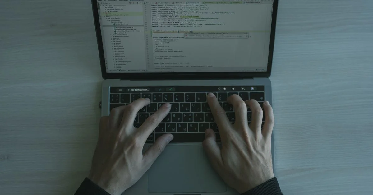 Vue rapprochée d'un programmeur codant sur un ordinateur portable, mettant en avant le développement de logiciels modernes.