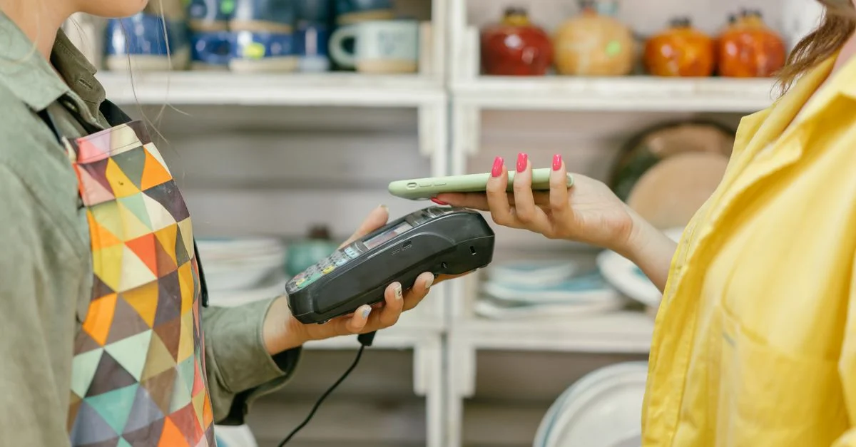 Un client effectue un paiement sans espèces en utilisant un smartphone dans un magasin de détail. La technologie moderne rencontre la commodité.