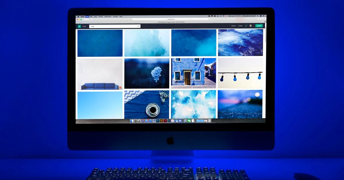 Espace de travail moderne avec un thème bleu lumineux et un moniteur d'ordinateur présentant une galerie d'images.