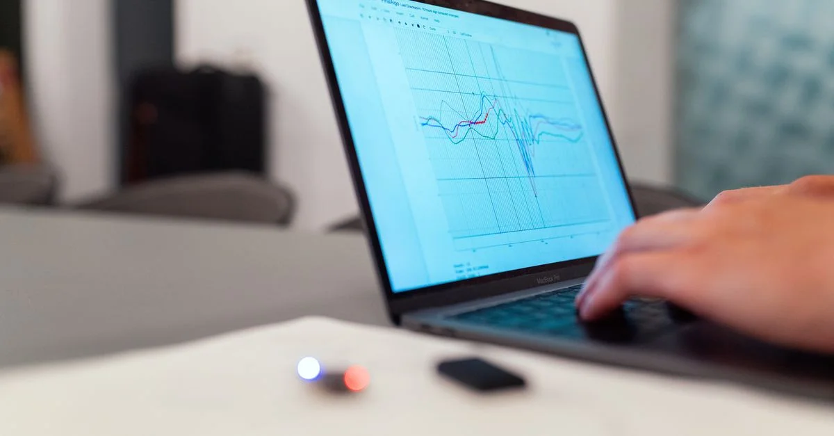 Une personne travaillant sur une analyse graphique sur un ordinateur portable pour la surveillance et la recherche de données.