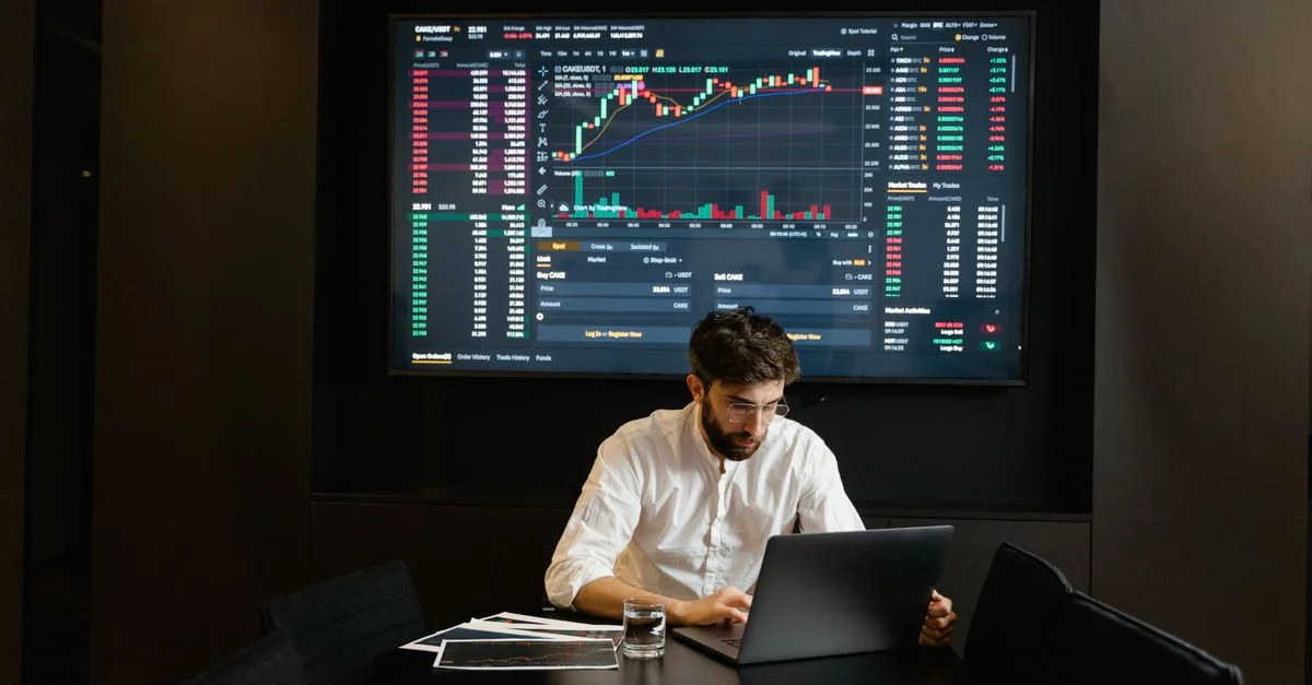 Homme d'affaires utilisant un ordinateur portable au bureau pour analyser des graphiques du marché boursier. Concept professionnel de finance et d'investissement.